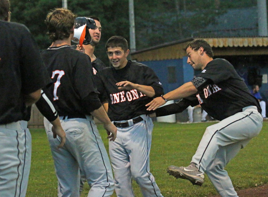 Oneonta's shortstop Tyler Martis is greeted by teammates after scoring the Outlaws first run in the top of the third inning at Hornell.  (Photo by Brian Horey a/k/aBRIANthePHOTOguy)