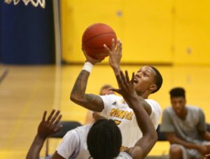 Omar Williams (center) gets in the lane for two of his game-high 20 points. (Photo courtesy of Monroe CC Athletics)