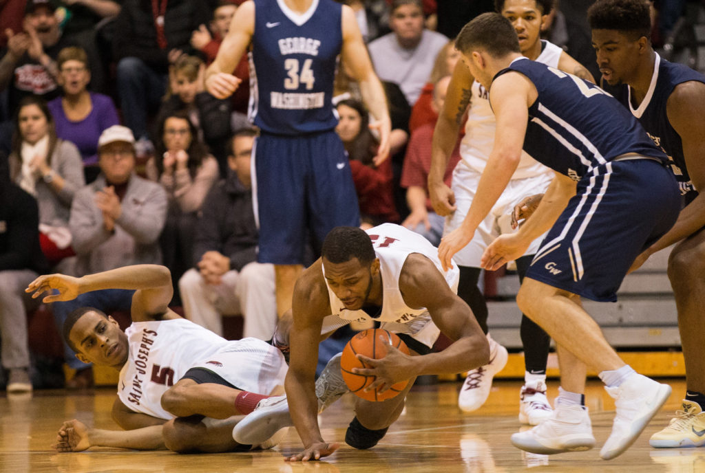 Saint Joseph's Hawks guard Chris Clover (15) dives for a loose ball in front of guard Nick Robinson (5) and George Washington Colonials guard Jaren Sina (23) during the second half at Michael J. Hagan Arena. The Saint Joseph's Hawks won 68-63. (Photo: Bill Streicher-USA TODAY Sports)